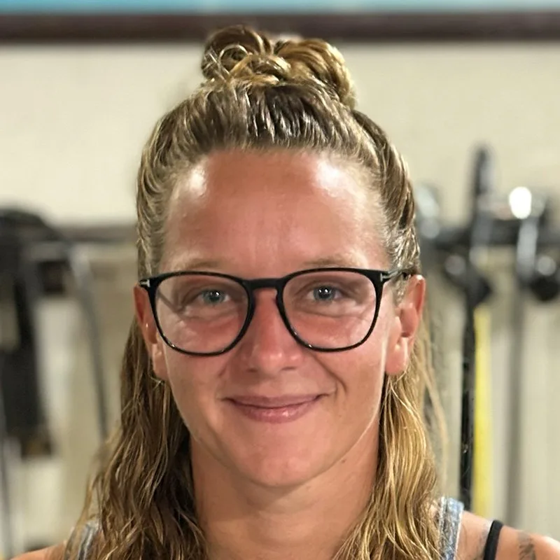 Portrait d'une femme souriante avec des lunettes et les cheveux attachés