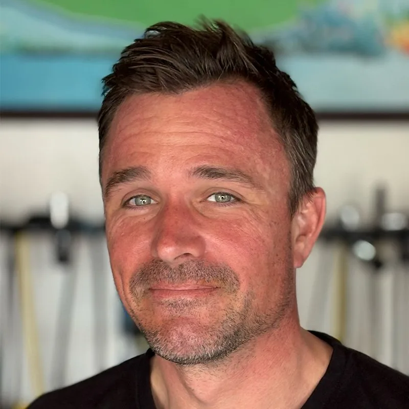 Portrait d'un homme souriant avec des cheveux bruns et des yeux bleus