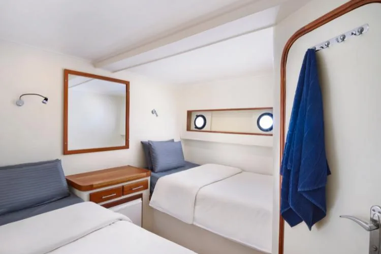 Cabine de bateau avec lits superposés, miroir et éclairage mural