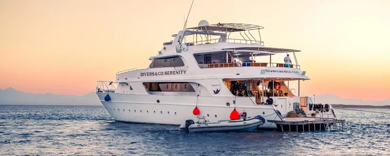 Grand bateau de plongée blanc sur l'eau au coucher du soleil