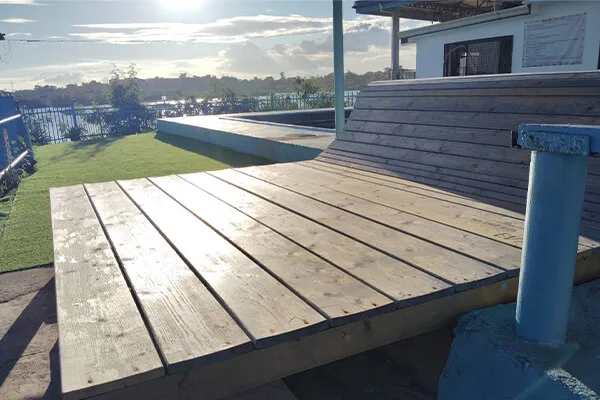 Terrasse en bois devant un bâtiment avec vue sur l'eau