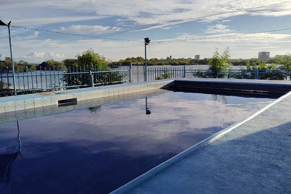 Piscine extérieure avec eau calme et ciel bleu en arrière-plan