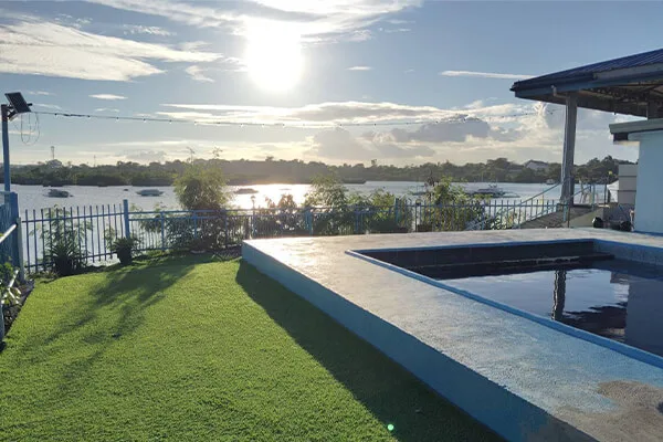 Vue d'un centre de plongée avec pelouse, piscine et bateaux amarrés