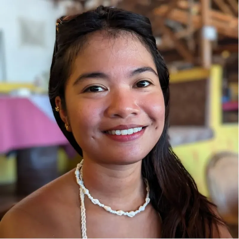 Portrait d'une jeune femme souriante avec des cheveux noirs et un collier