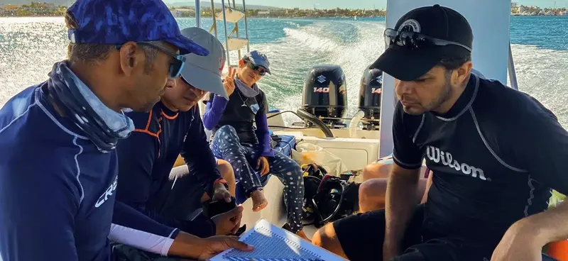 Plongeurs préparant une sortie en bateau, regardant une carte marine