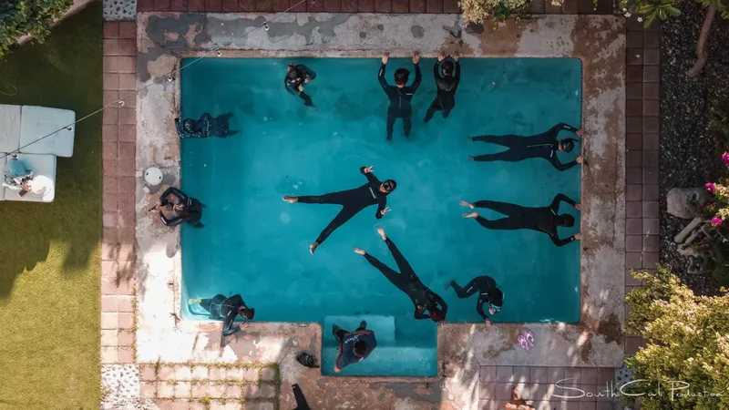 Groupe de personnes en combinaisons noires flottant dans une piscine