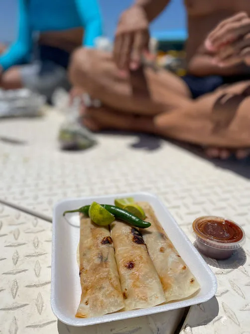 Assiettes de nourriture sur un bateau avec des jambes en arrière-plan