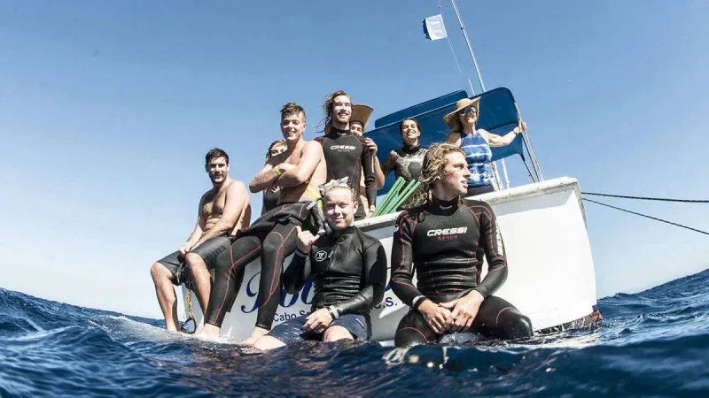 Groupe de plongeurs souriants à bord d'un bateau en mer