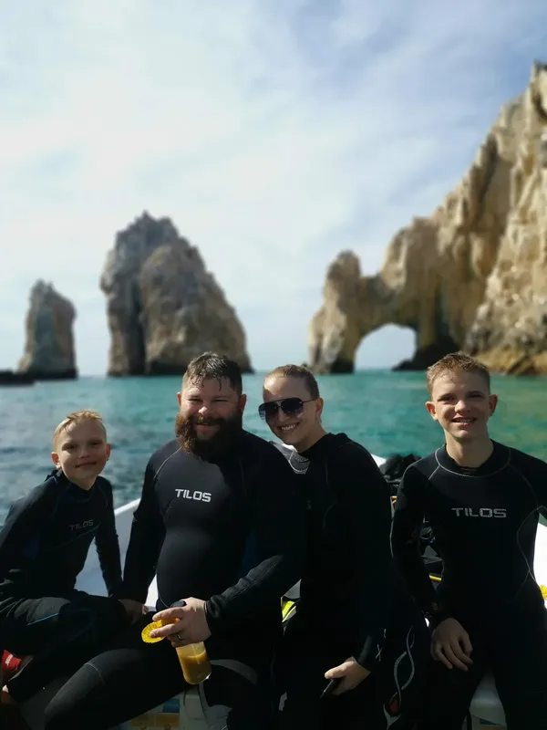 Quatre personnes en combinaison de plongée sur un bateau en mer