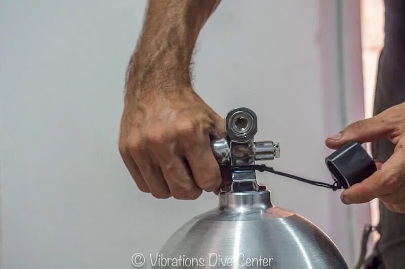 Préparation d'une bouteille de plongée avec un détendeur et un bouchon