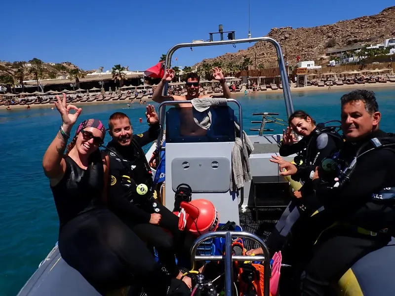 Groupe de plongeurs souriants à bord d'un bateau semi-rigide en mer