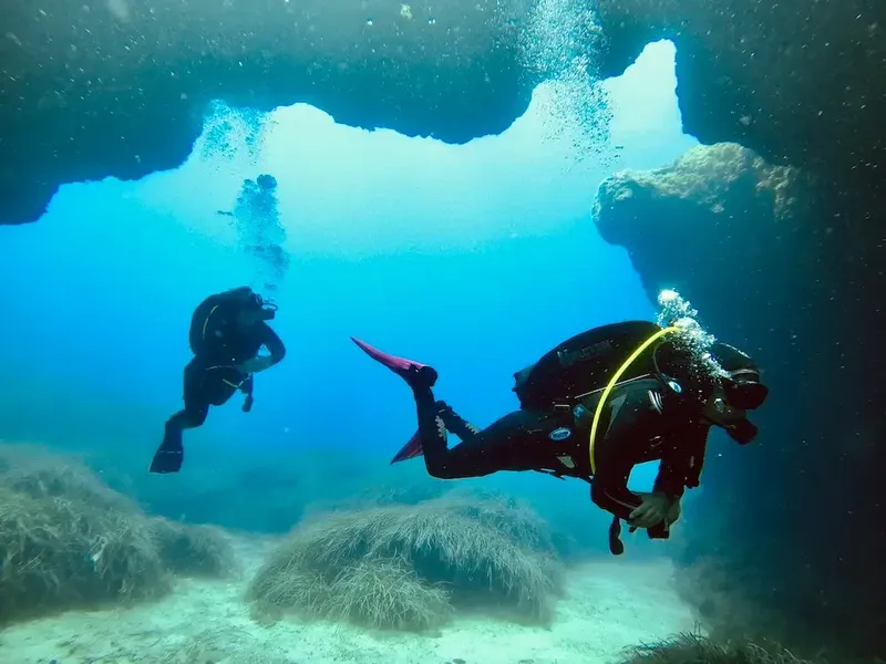 Deux plongeurs explorent une grotte sous-marine avec de la lumière