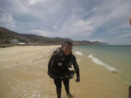 Plongeur souriant sortant de l'eau sur une plage ensoleillée