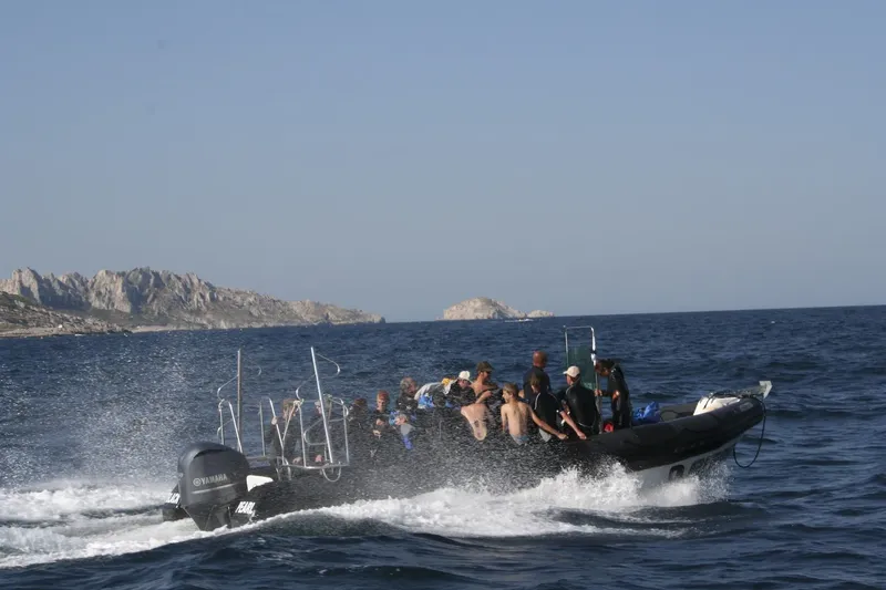 Groupe de plongeurs à bord d'un bateau semi-rigide en mer
