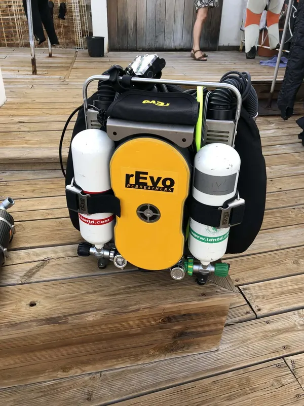 Equipement de plongée rebreather jaune et noir sur une terrasse bois
