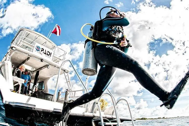 Plongeur s'apprête à sauter d'un bateau de plongée en combinaison