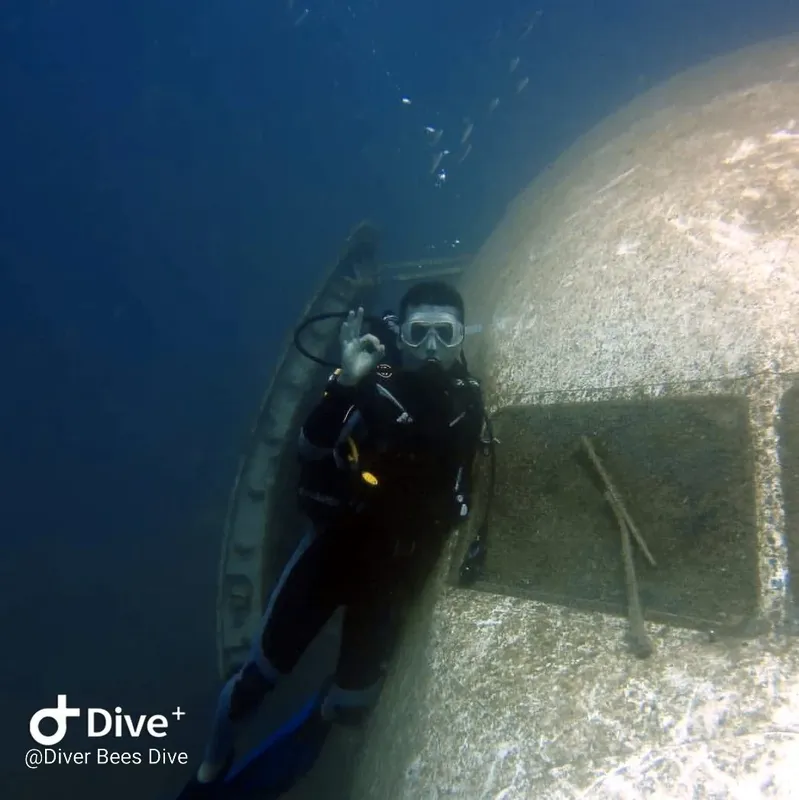 Plongeur explore une épave sous-marine avec une visibilité moyenne