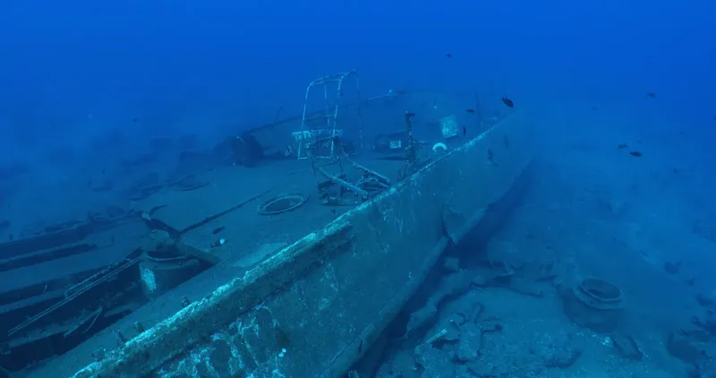 Épave de bateau coulé reposant sur le fond marin bleu