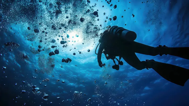 Plongeur en silhouette remontant dans une eau bleue et lumineuse
