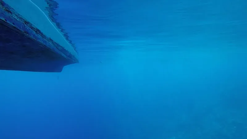 Vue sous-marine d'une coque de bateau bleu dans l'eau
