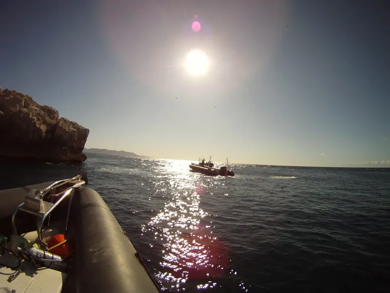 Vue mer depuis un bateau, soleil brillant, autre bateau au loin