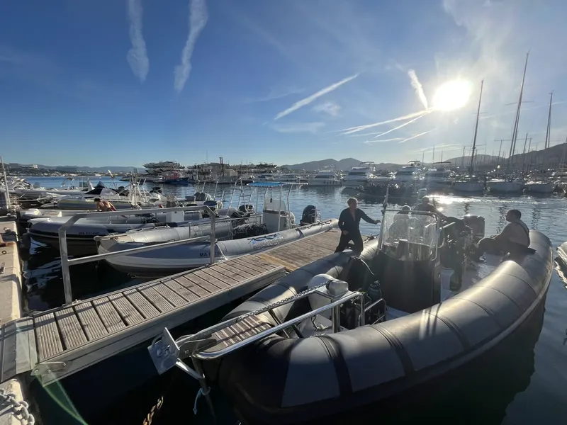 Port de plaisance ensoleillé avec des bateaux et des personnes sur un ponton