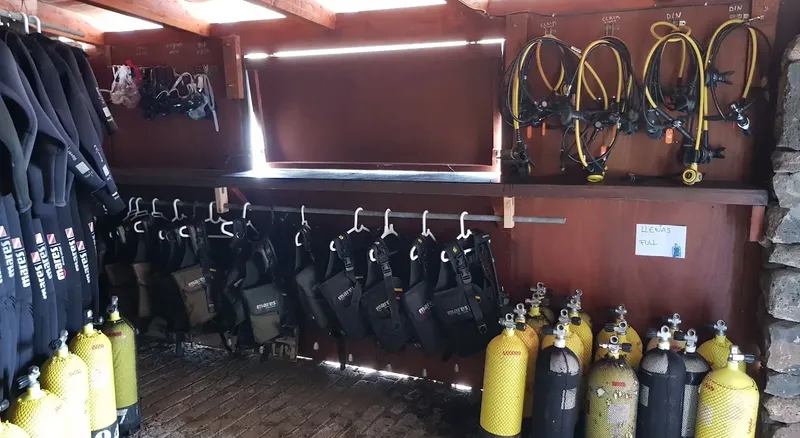 Equipement de plongée complet rangé dans un local sombre et rustique