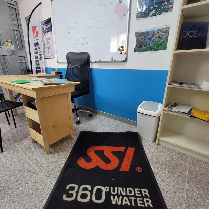 Bureau d'accueil avec logo SSI et plan de plongée au mur