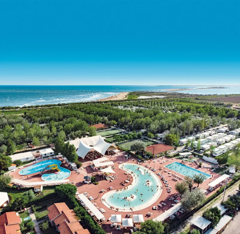 Vue aérienne d'un complexe touristique avec piscines et végétation luxuriante