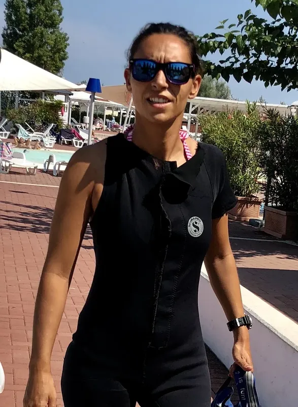 Femme souriante portant un gilet de plongée noir et des lunettes de soleil