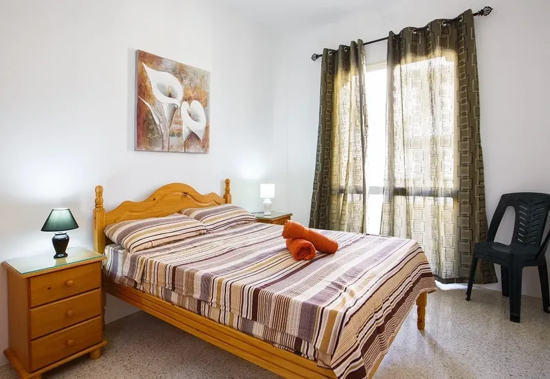 Chambre d'hôtel lumineuse avec un lit double et une décoration florale