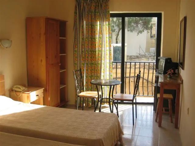 Chambre d'hôtel simple avec lit, bureau, et vue sur l'extérieur