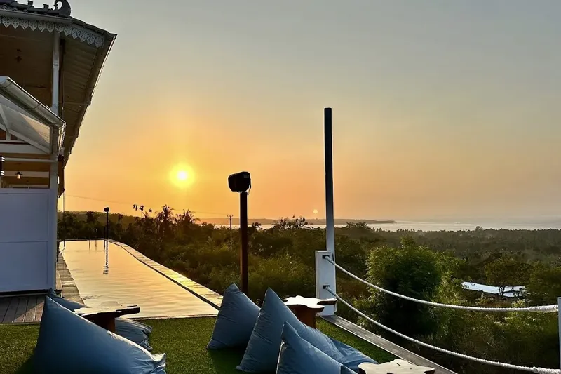 Coucher de soleil sur l'océan vu depuis une terrasse avec piscine