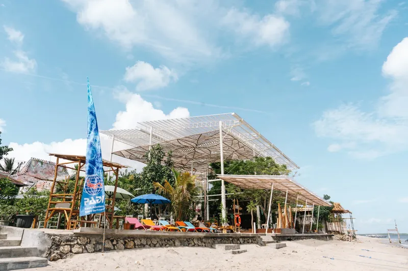 Terrasse ombragée d'un centre de plongée sur une plage ensoleillée