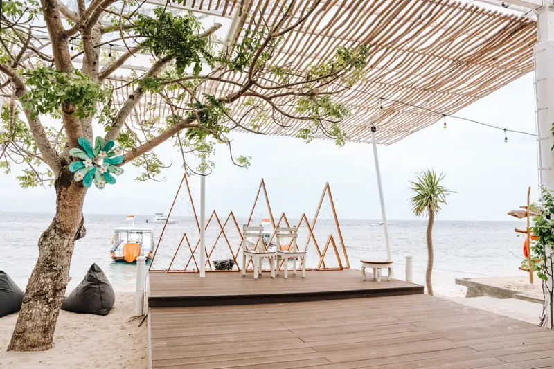 Terrasse en bois avec mobilier, vue sur la mer et bateaux
