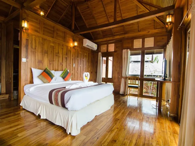 Chambre en bois avec lit double, décoration et éclairage chaleureux