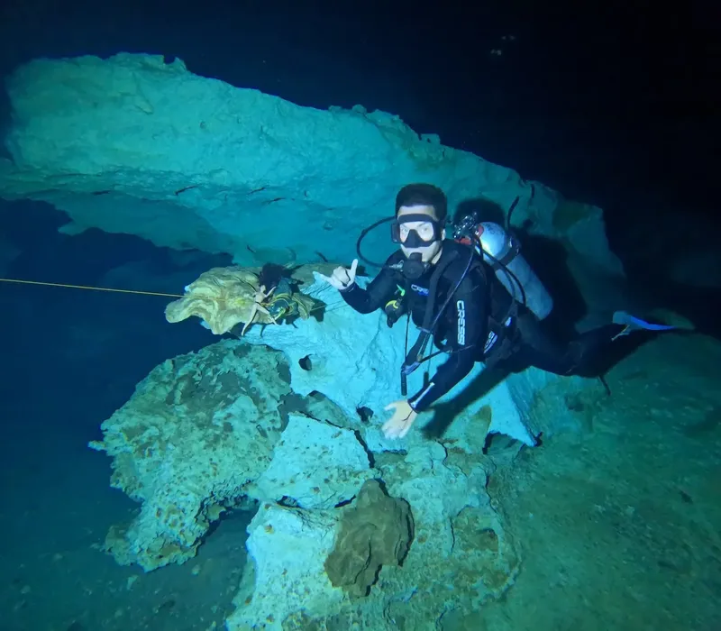 Plongeur en grotte sous-marine avec étoile de mer et signe de paix