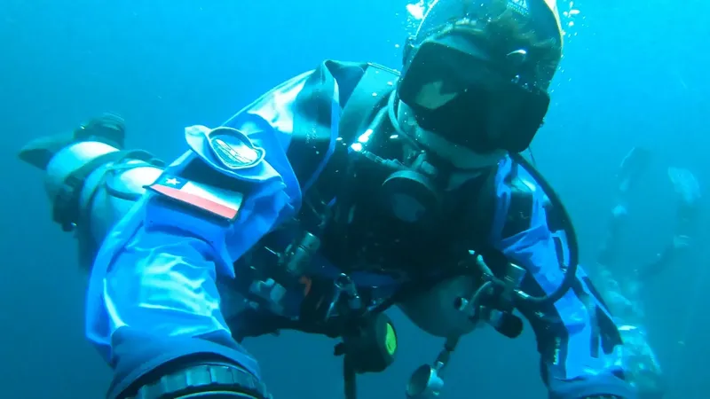 Plongeur en combinaison étanche évolue dans une eau bleue claire