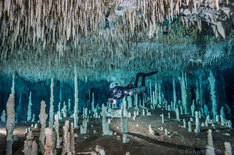 Plongeur explore une grotte sous-marine avec des stalactites et stalagmites