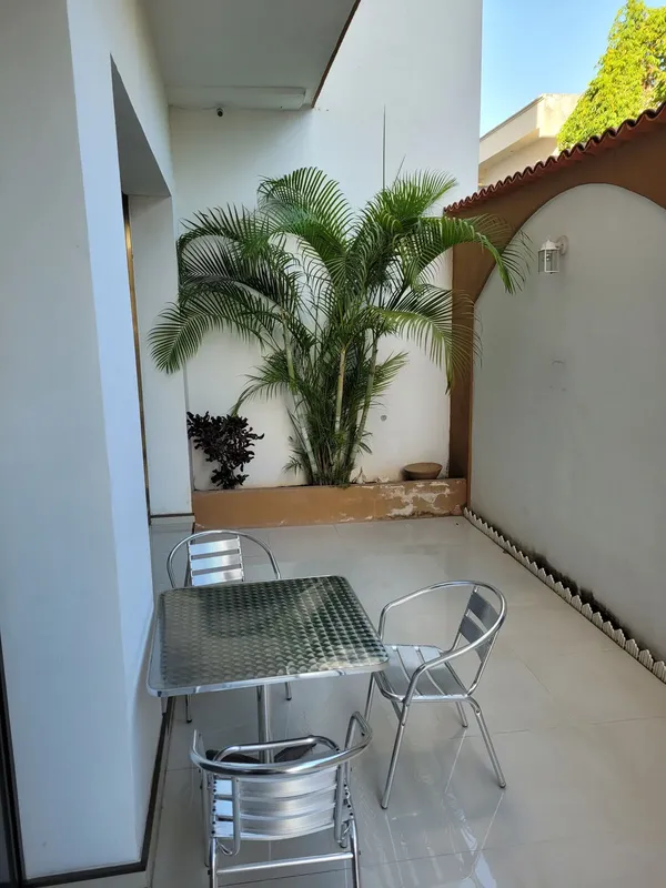 Coin détente extérieur avec table, chaises et plantes tropicales