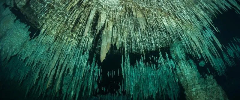 Stalactites et formations rocheuses sous-marines dans une grotte turquoise