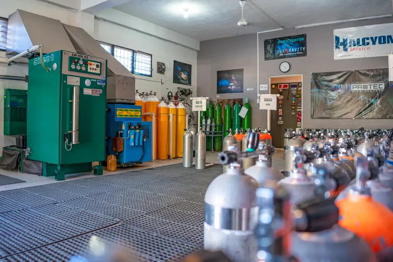 Atelier de remplissage de bouteilles avec compresseur et rangées de bouteilles