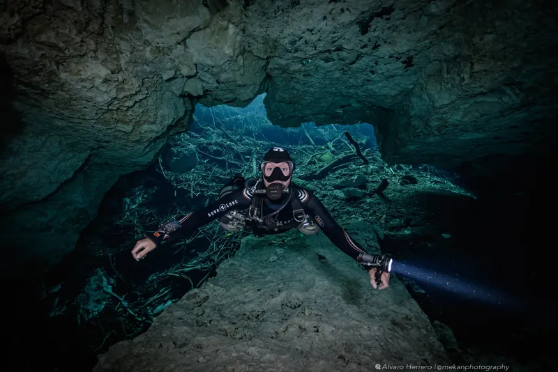 Plongeur explorant une grotte sous-marine avec une lumière puissante