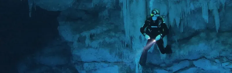 Plongeur explore une grotte sous-marine illuminée par une lampe torche