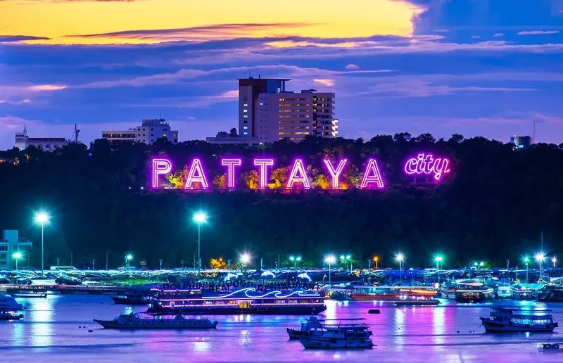Vue nocturne de Pattaya city avec bateaux illuminés et bâtiments