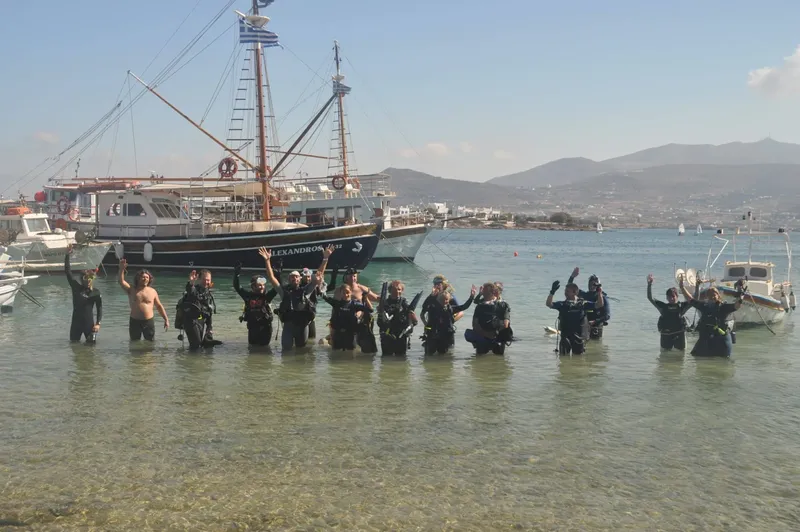 Groupe de plongeurs en combinaison sur une plage ensoleillée