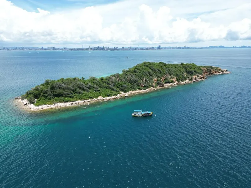 Île tropicale avec végétation luxuriante et un bateau en mer