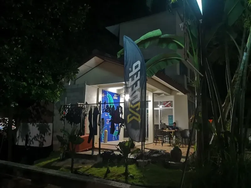 Façade d'un centre de plongée avec des combinaisons et un drapeau