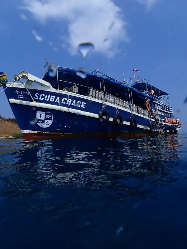 Bateau de plongée bleu et blanc sur une mer calme ensoleillée