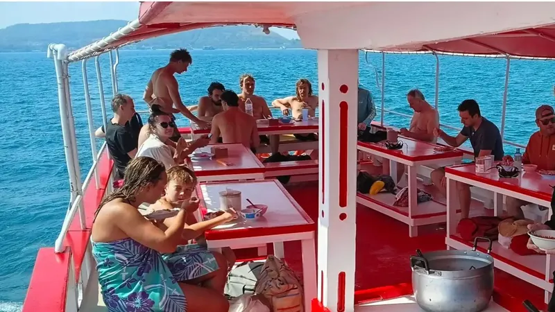 Groupe de personnes sur un bateau, mangeant et se relaxant en mer